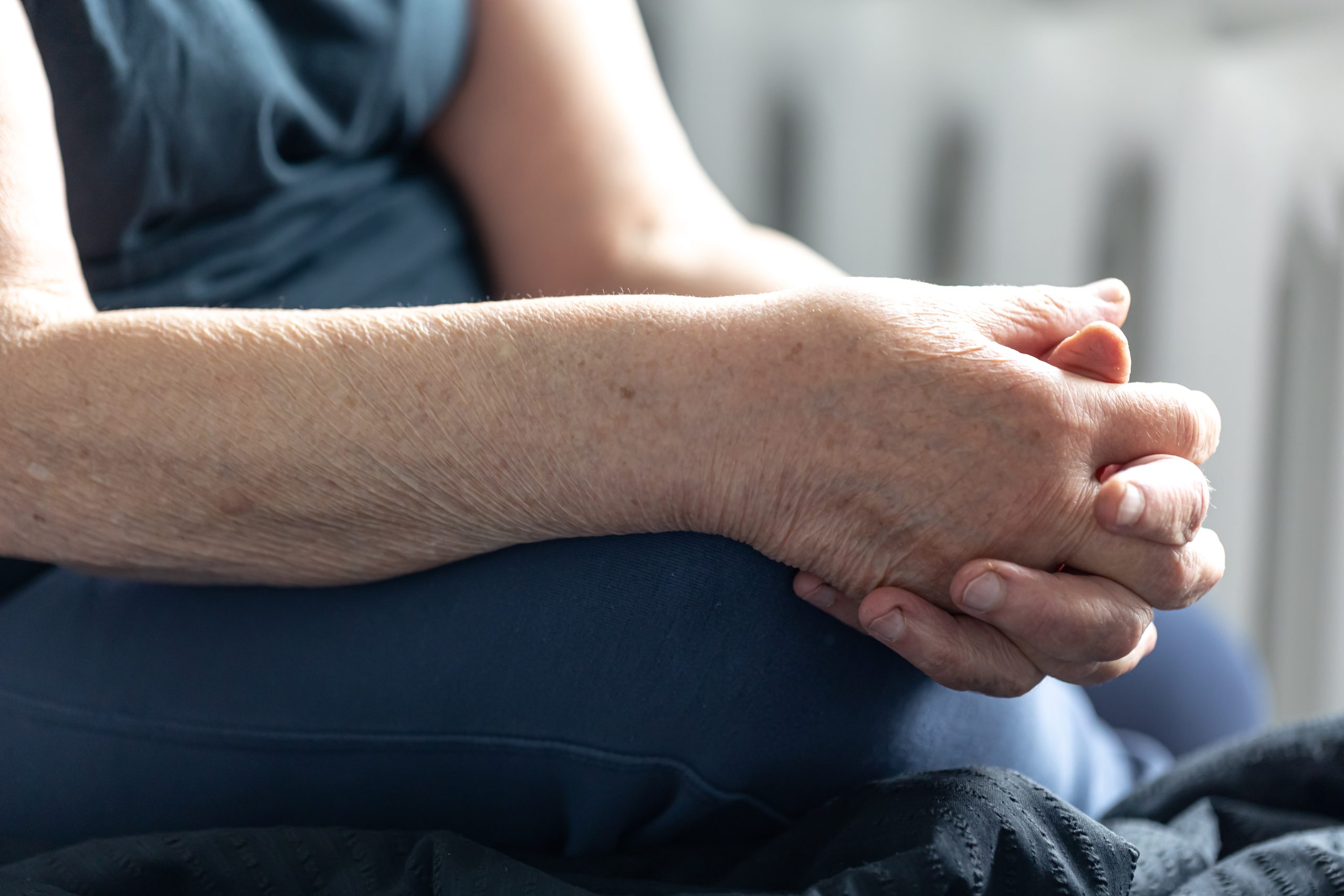 Close-up, hands of an elderly woman, an old woman sits with her hands folded.